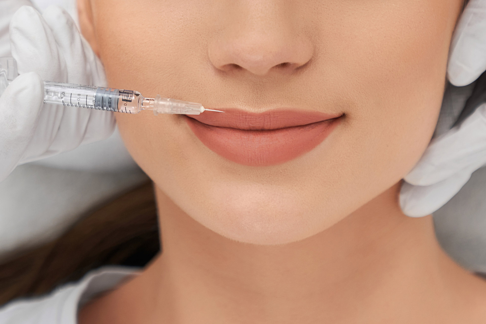 A person getting lip injections done by a beauty expert 