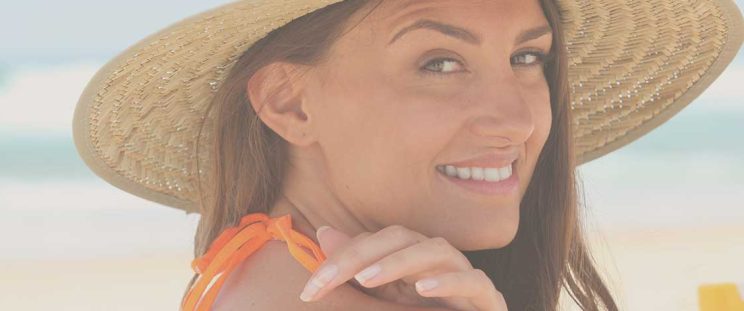 Girl wearing hat putting sunscreen on to avoid uneven skin tone by APT Medical Aeshetics
