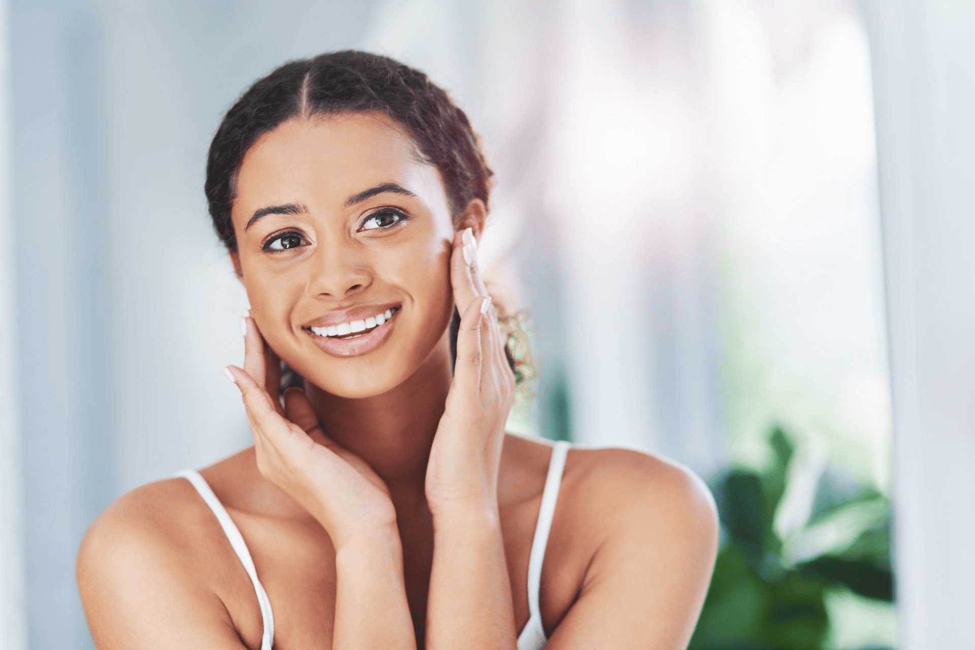  A photo of a woman smiling and touching her cheeks. 