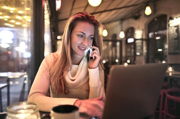 Woman using her phone and laptop
