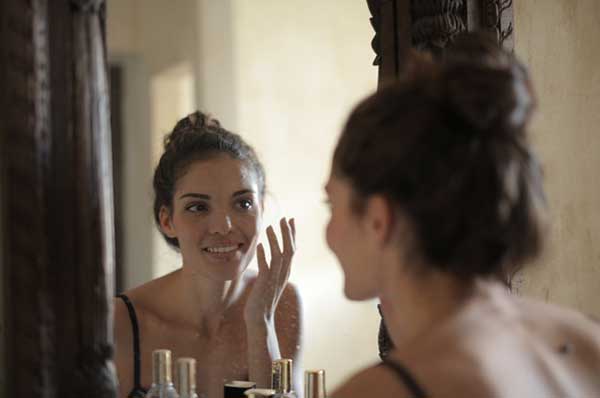 Woman in front of the mirror doing skincare 