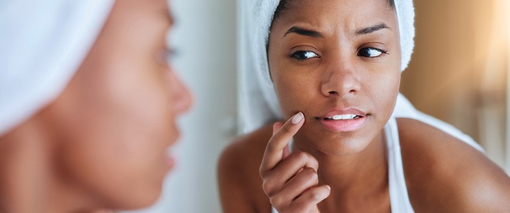 A woman checking her skin in a mirror