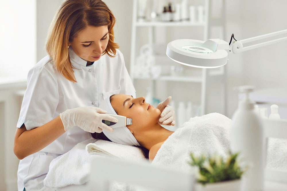 A skin care expert performing a facial on a patient