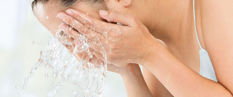 A woman washes her face after undergoing a Morpheus8 treatment