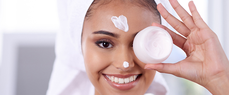 A woman applying moisturizer on her face