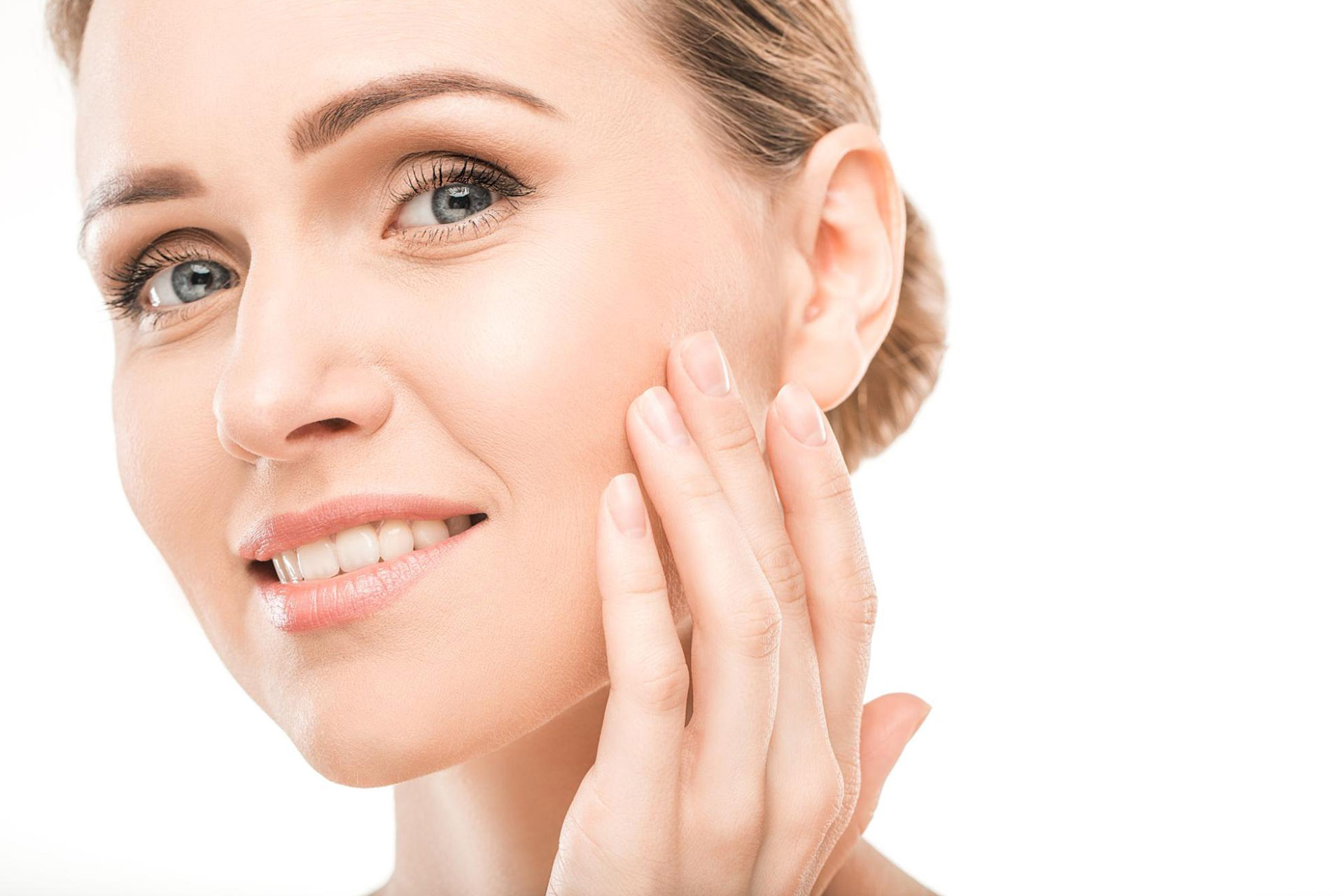  A smiling woman touches her face after a successful dermal filler treatment