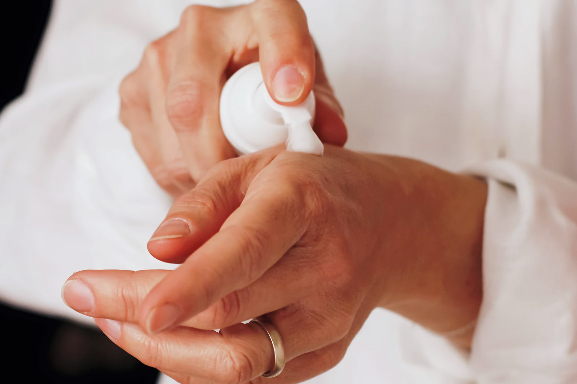  A person applying moisturizer on one hand