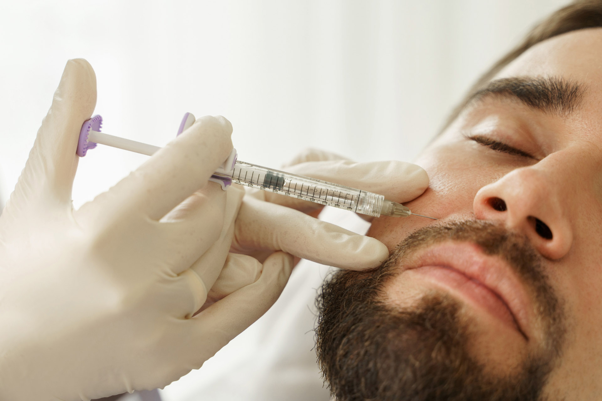  a man receiving dermal fillers in his nasolabial folds