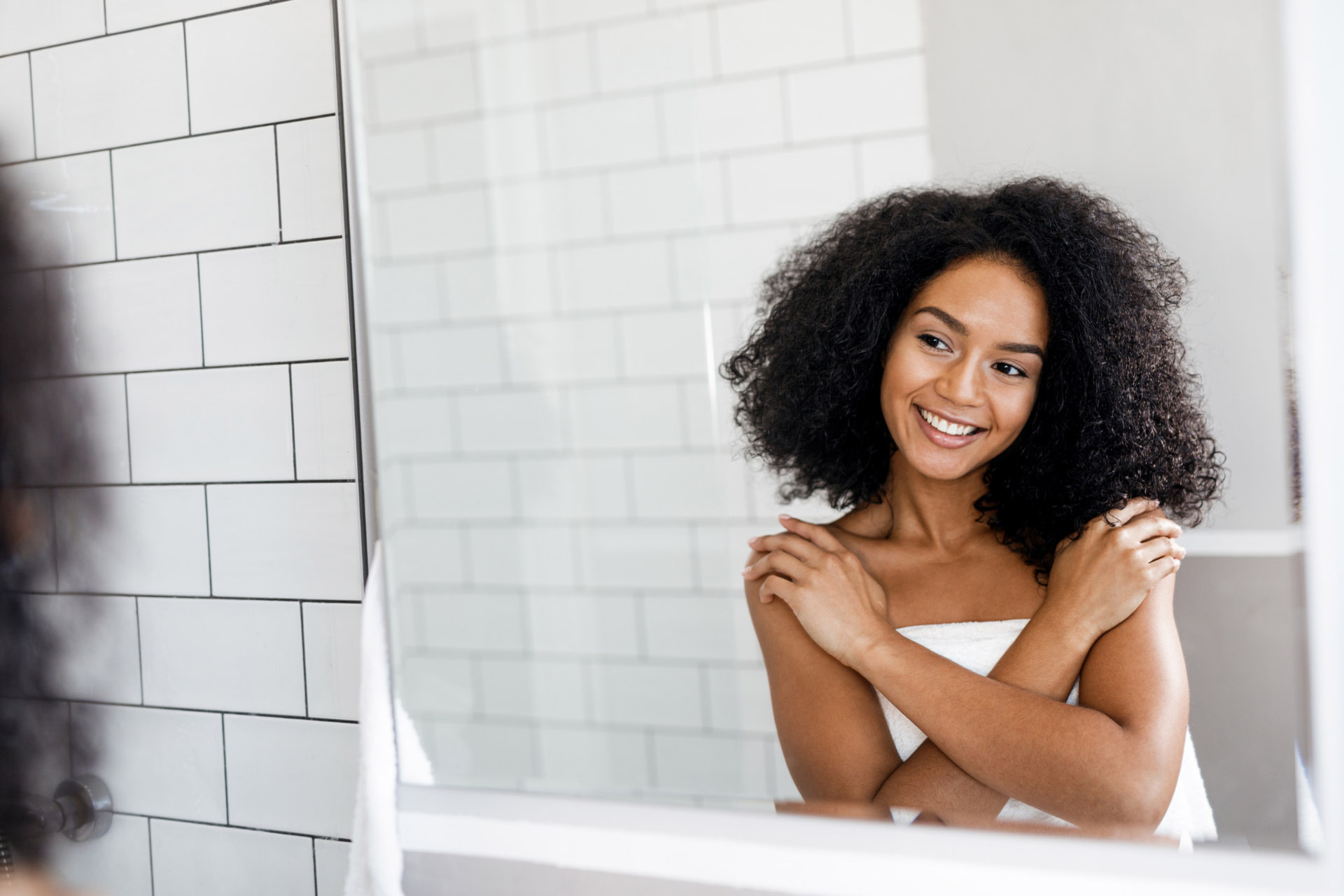 a woman smiling at herself in the mirror