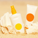Bottles of sun-care products on the sand at the beach
