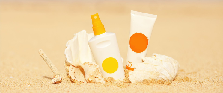 Bottles of sun-care products on the sand at the beach