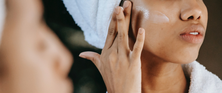 A woman putting on face cream