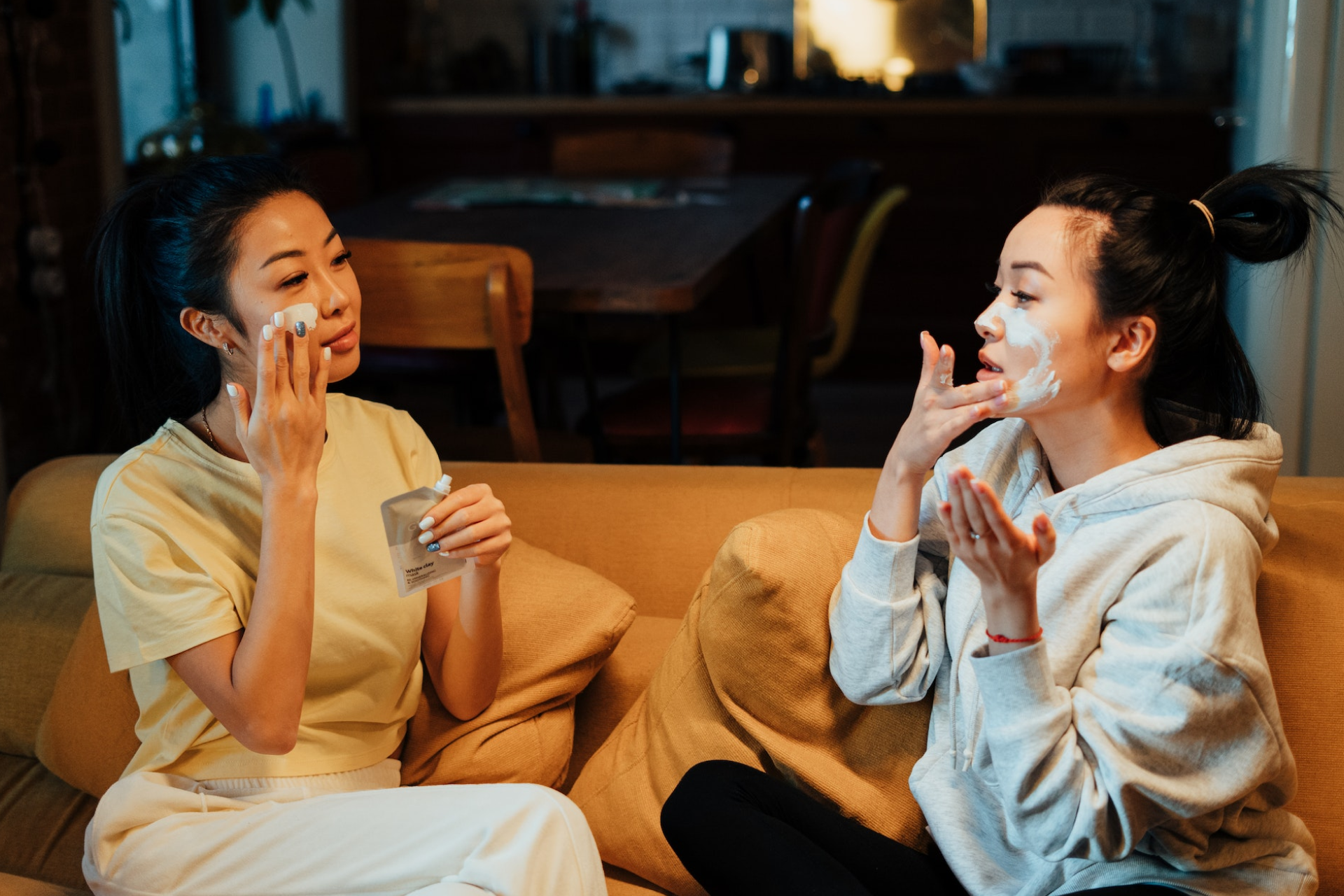 Two women putting on skincare products 