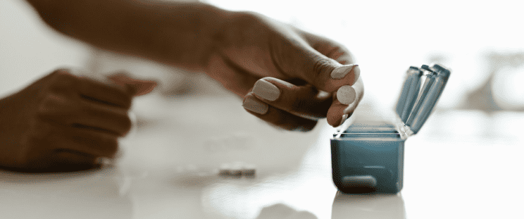 A person placing progesterone pills inside a container