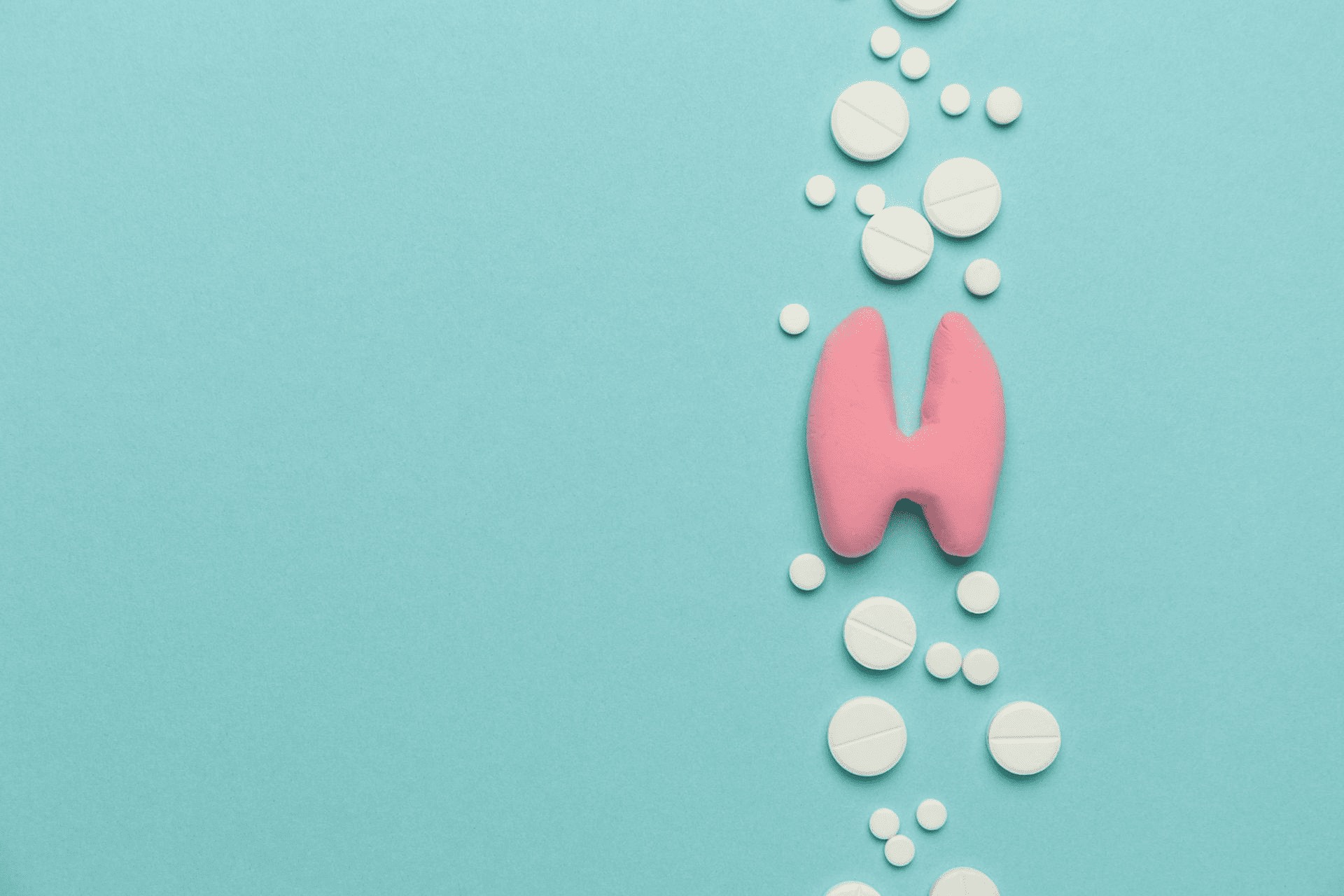  A clay model of a thyroid gland surrounded by pills. 