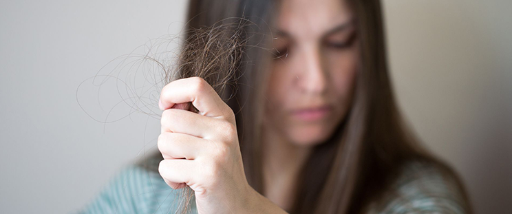 A woman holding up a clump of her hair
