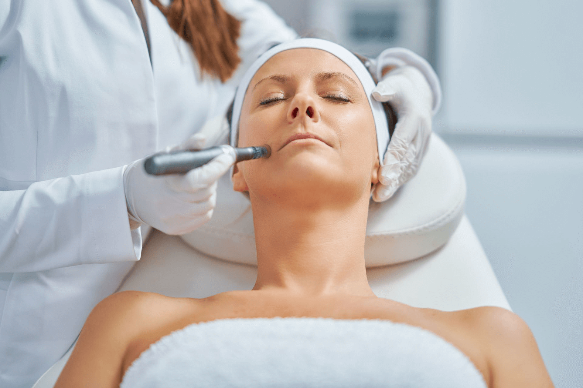 A woman receiving microneedling treatment on her cheek 