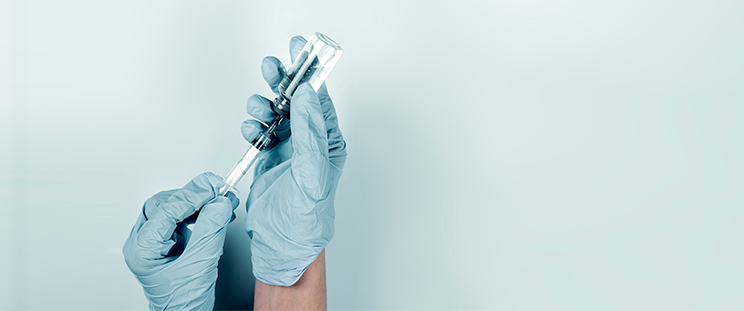 A medical professional draws a syringe